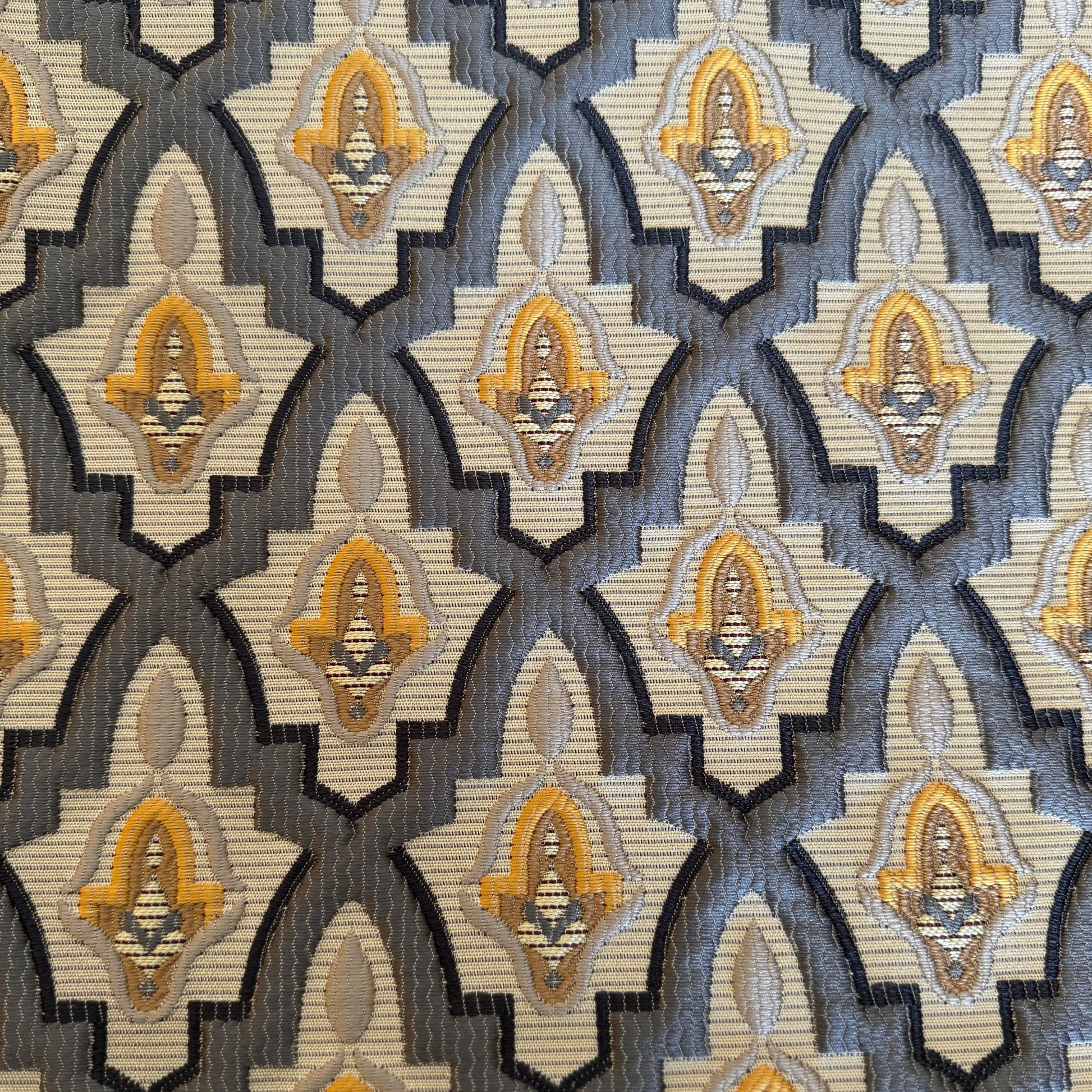 Tissu d'ameublement marocain à motif arabesque en relief( zellij) , dans des tons gris , jaune tissé au Maroc pour salons marocains, coussins et décoration intérieure.
