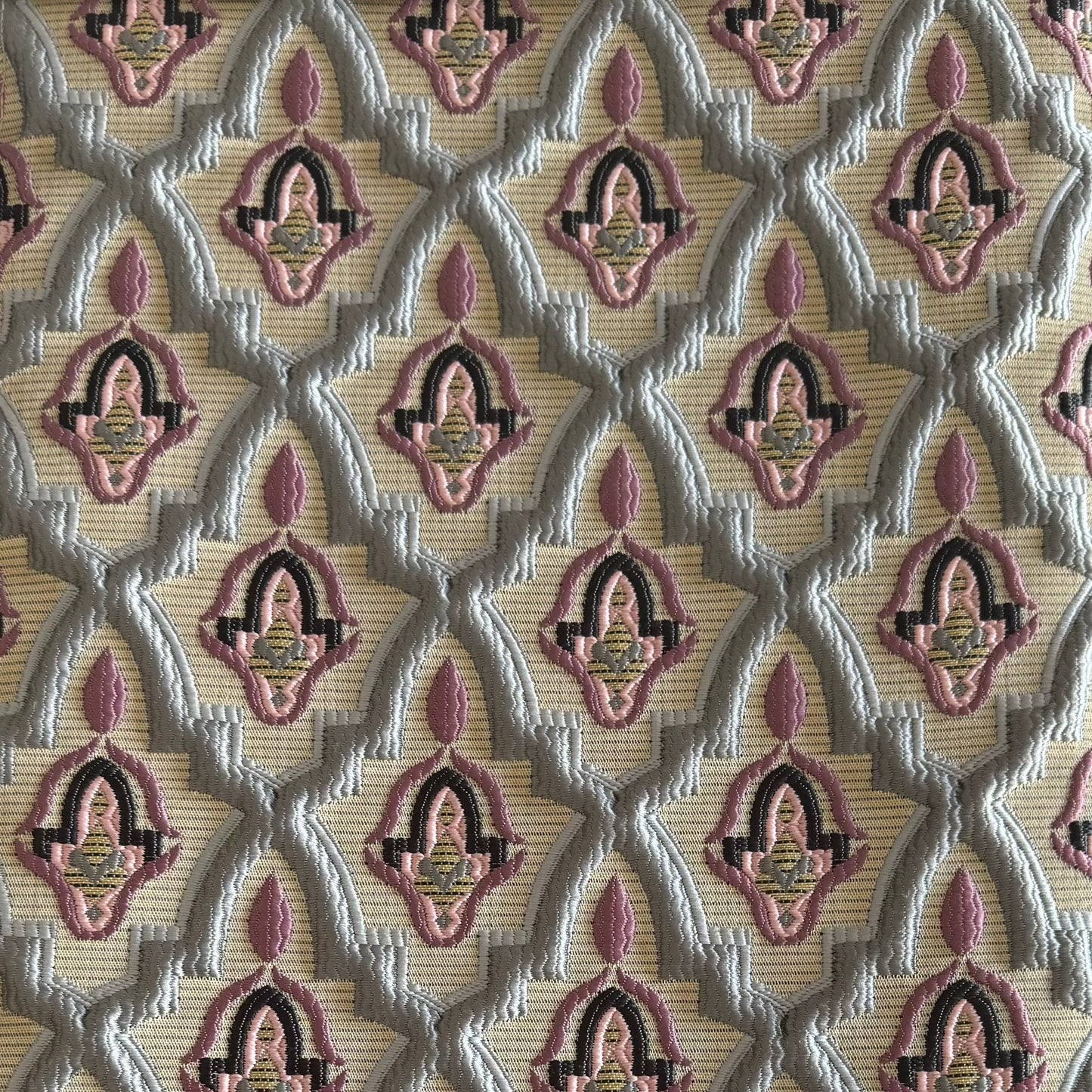 Tissu d'ameublement marocain à motif arabesque en relief( zellij) , dans des tons gris et rose tissé au Maroc pour salons marocains, coussins et décoration intérieure.