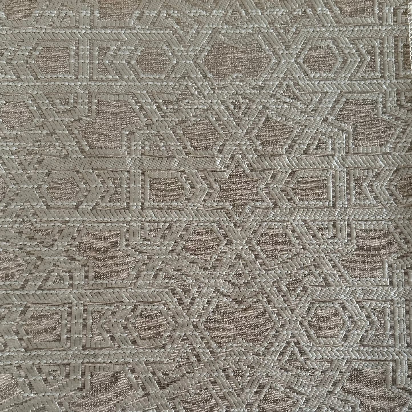 Tissu d'ameublement Zellij tissé au Maroc dans des tons écru et greige, avec un motif géométrique en relief inspiré des mosaïques marocaines, idéal pour salons, coussins et décoration intérieure.