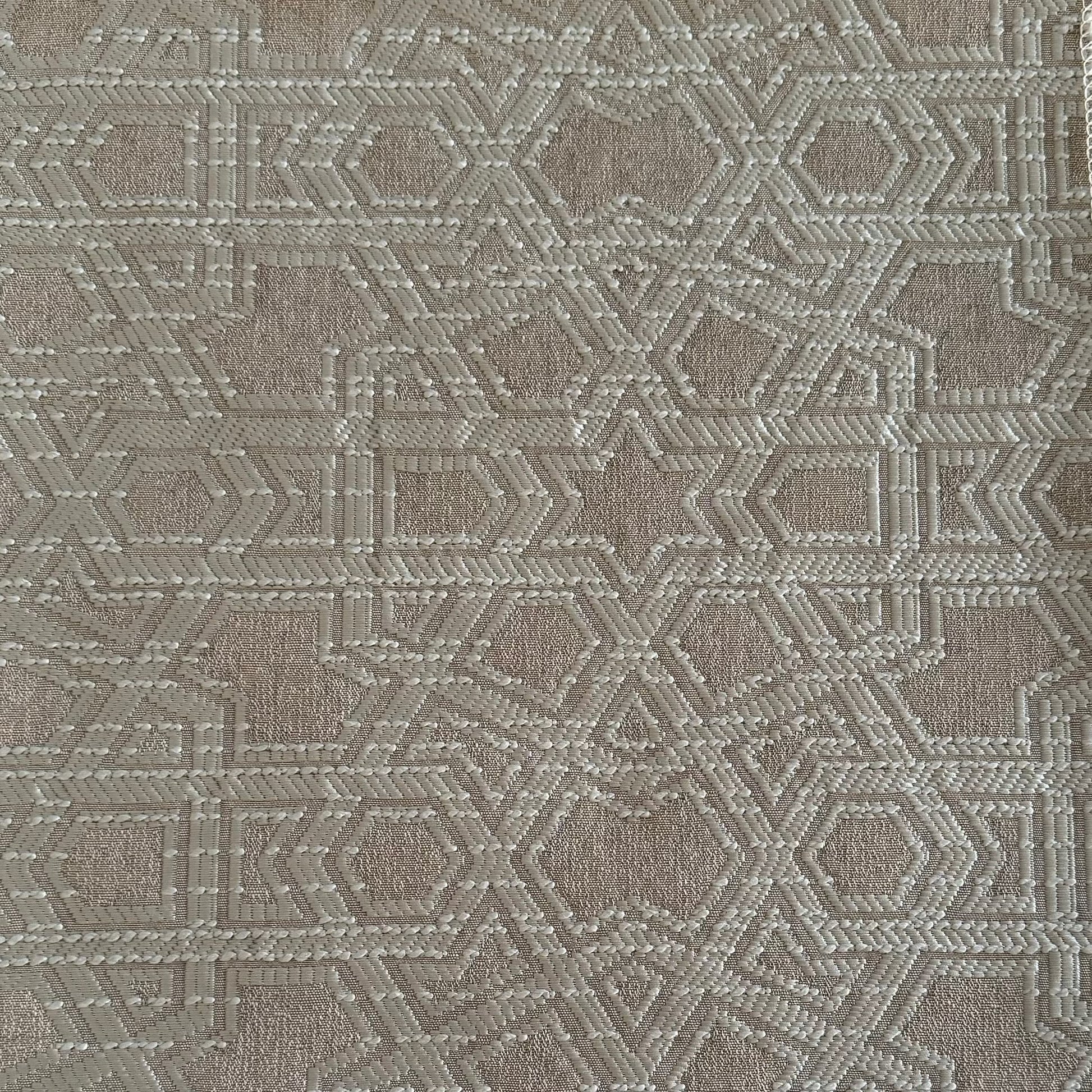 Tissu d'ameublement Zellij tissé au Maroc dans des tons écru et greige, avec un motif géométrique en relief inspiré des mosaïques marocaines, idéal pour salons, coussins et décoration intérieure.