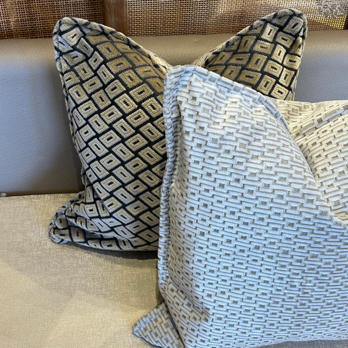 Duo de coussins décoratifs marocains avec coussin ethnique géométrique noir et écru et coussin uni ivoire texturé, finition haut de gamme.