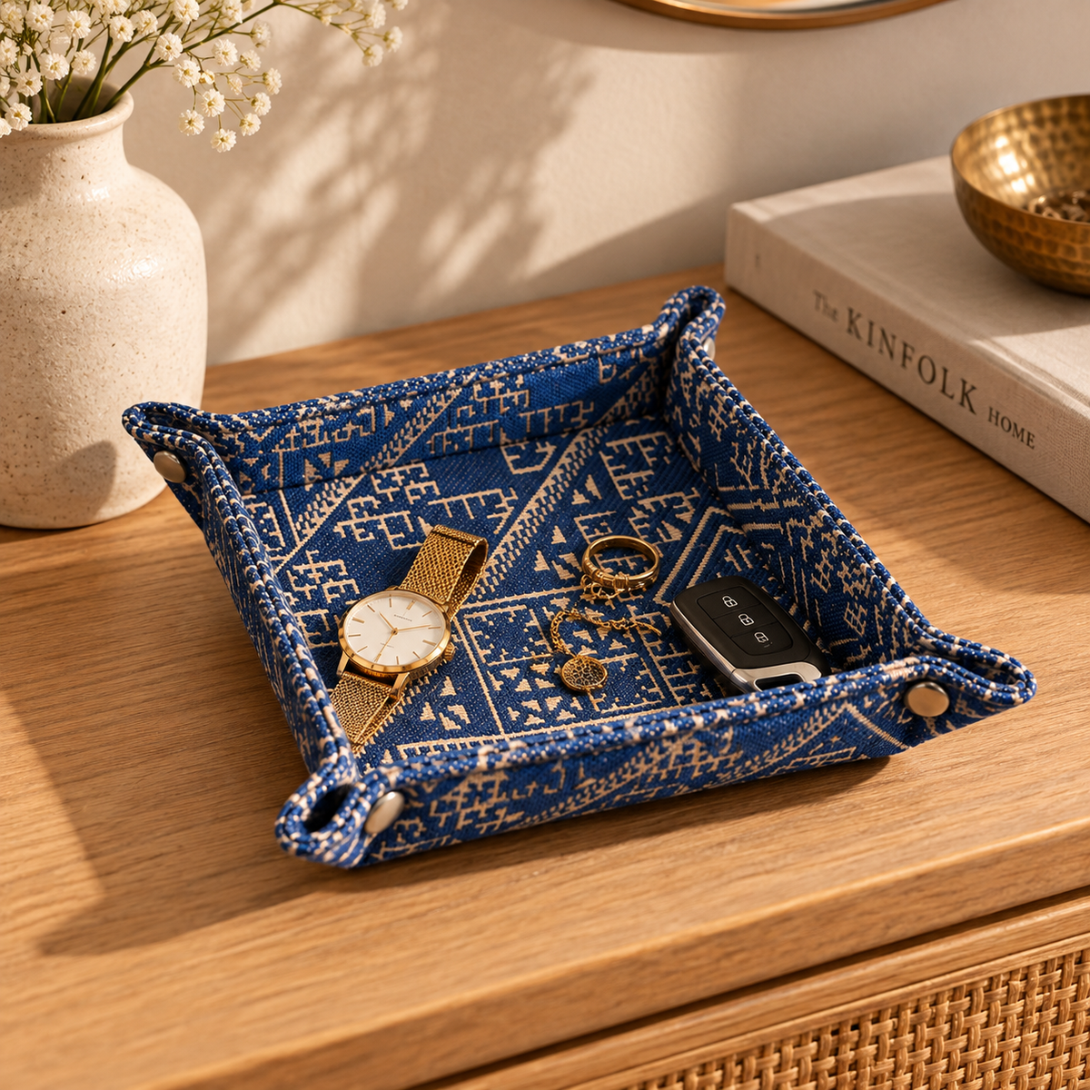 Vide-poche en tissu Tarz bleu à motifs géométriques, posé sur une console en bois avec montre, bijoux et clés – Biyadi Collection.