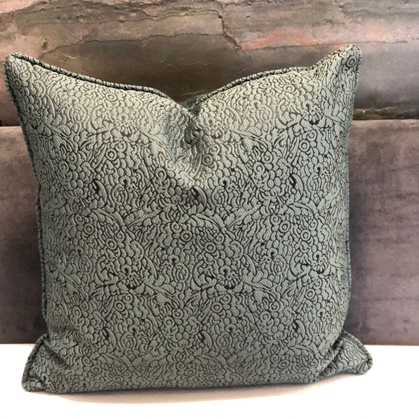 Coussin décoratif vert  à motif floral en relief, tissu marocain élégant pour salon chic et contemporain.