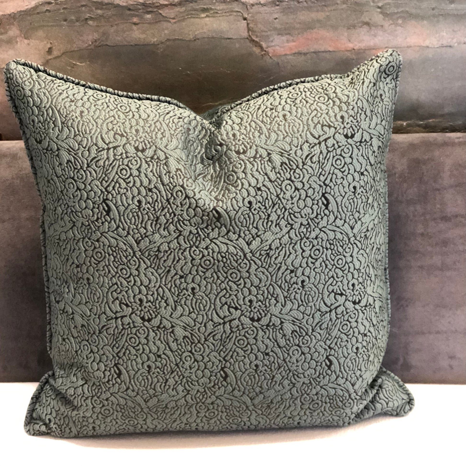 Coussin décoratif vert  à motif floral en relief, tissu marocain élégant pour salon chic et contemporain.