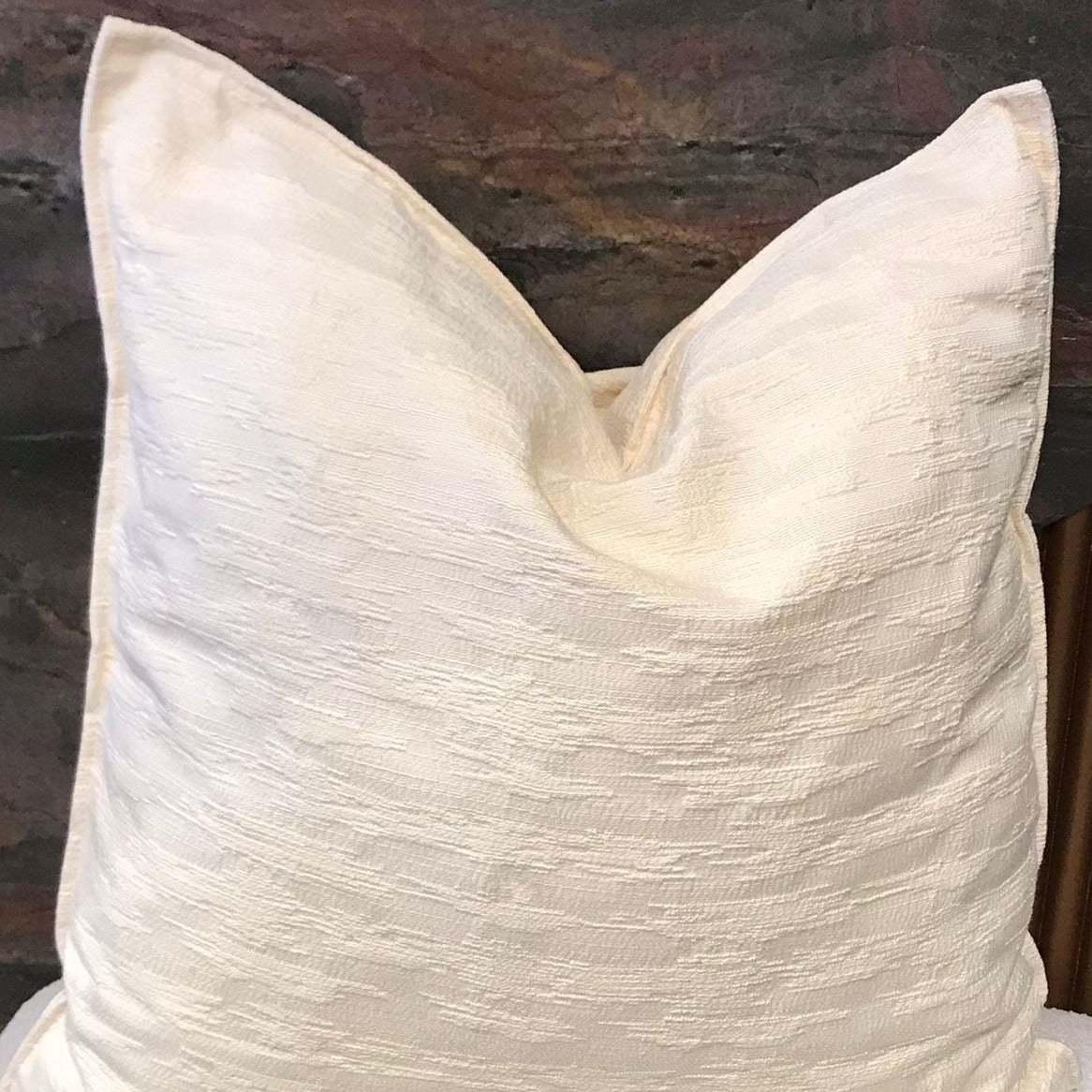 Coussin décoratif écru en tissu texturé relief, au style élégant et minimaliste, idéal pour une décoration de salon moderne et raffinée.