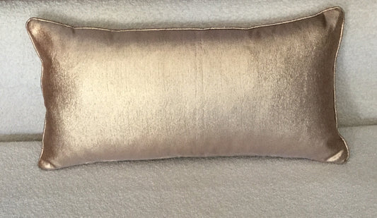 Coussin rectangulaire uni bronze en tissu lumineux légèrement satiné, posé sur un canapé clair