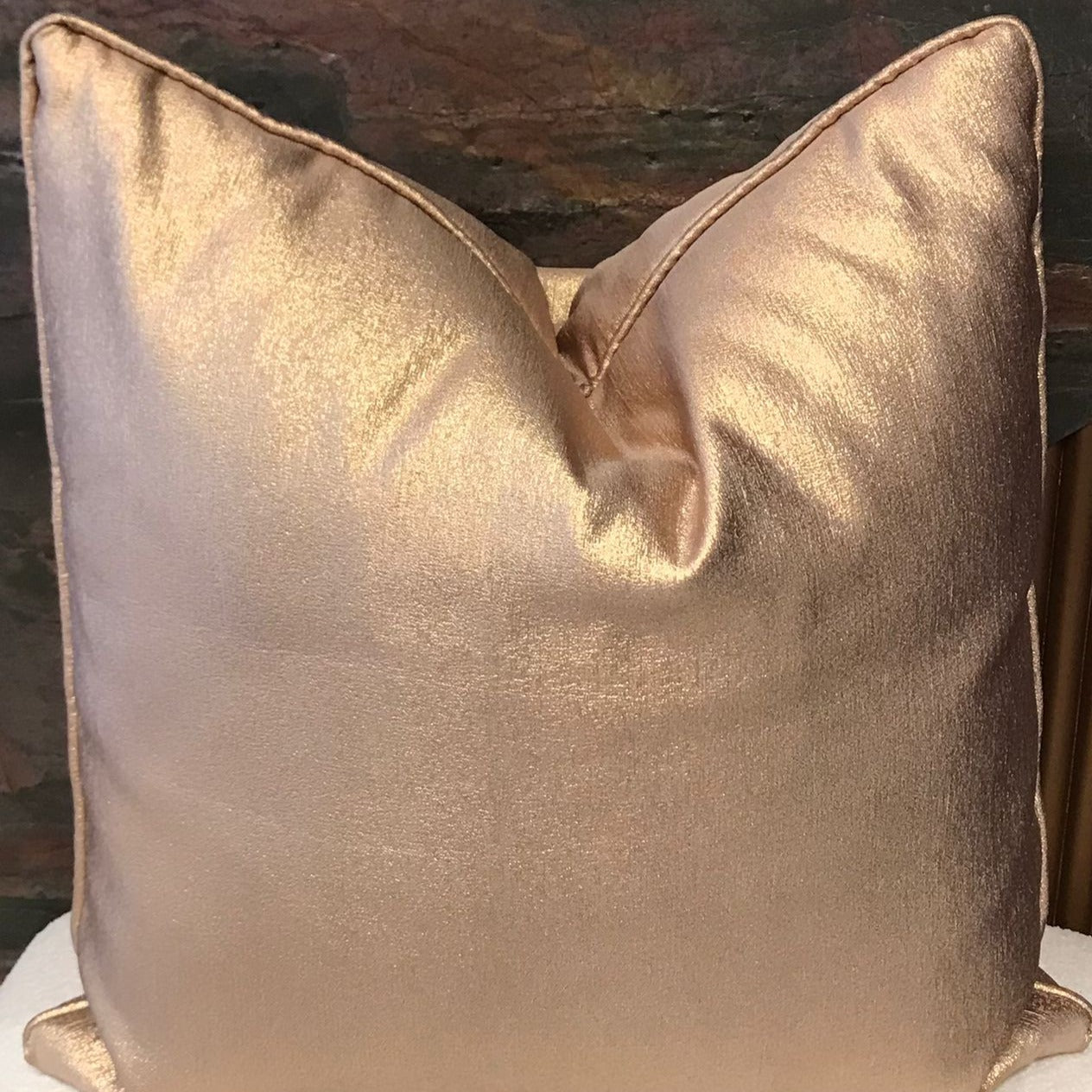 Coussin décoratif uni bronze satiné avec effet lumineux et finition élégante, idéal pour un salon chic et contemporain.