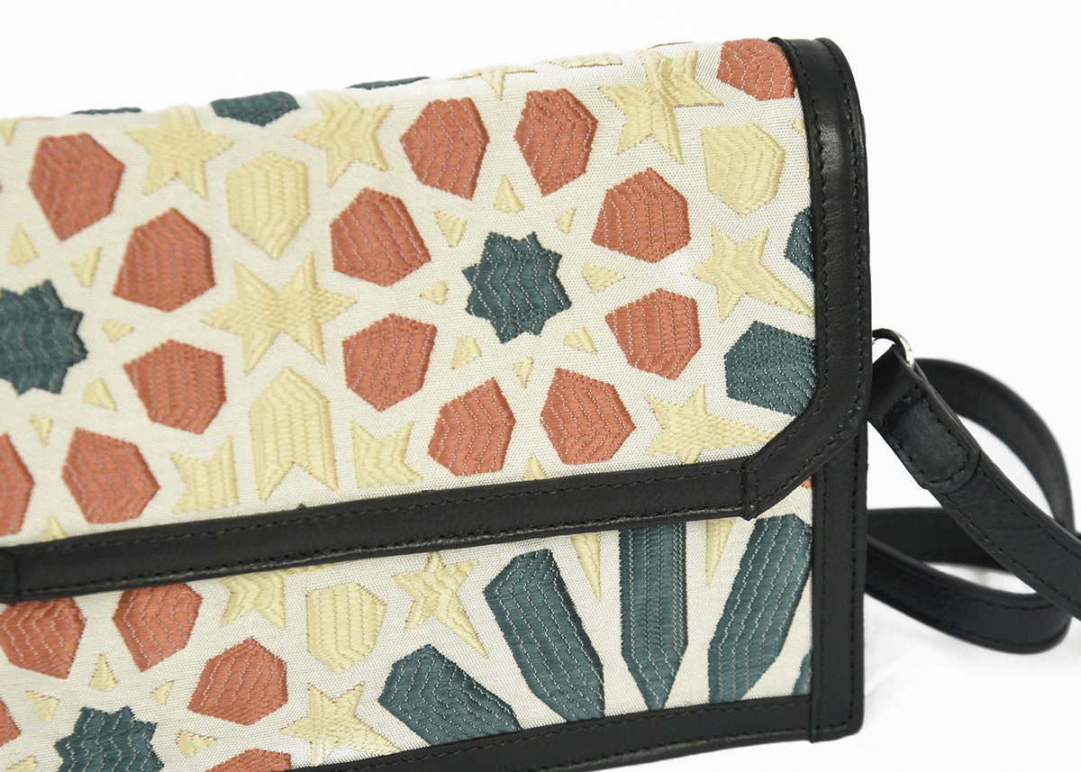 Gros plan sur le motif Zellij multicolore terracotta, vert et écru d’un sac bandoulière Biyadi Collection, mettant en valeur le tissage en relief et les finitions noires.
