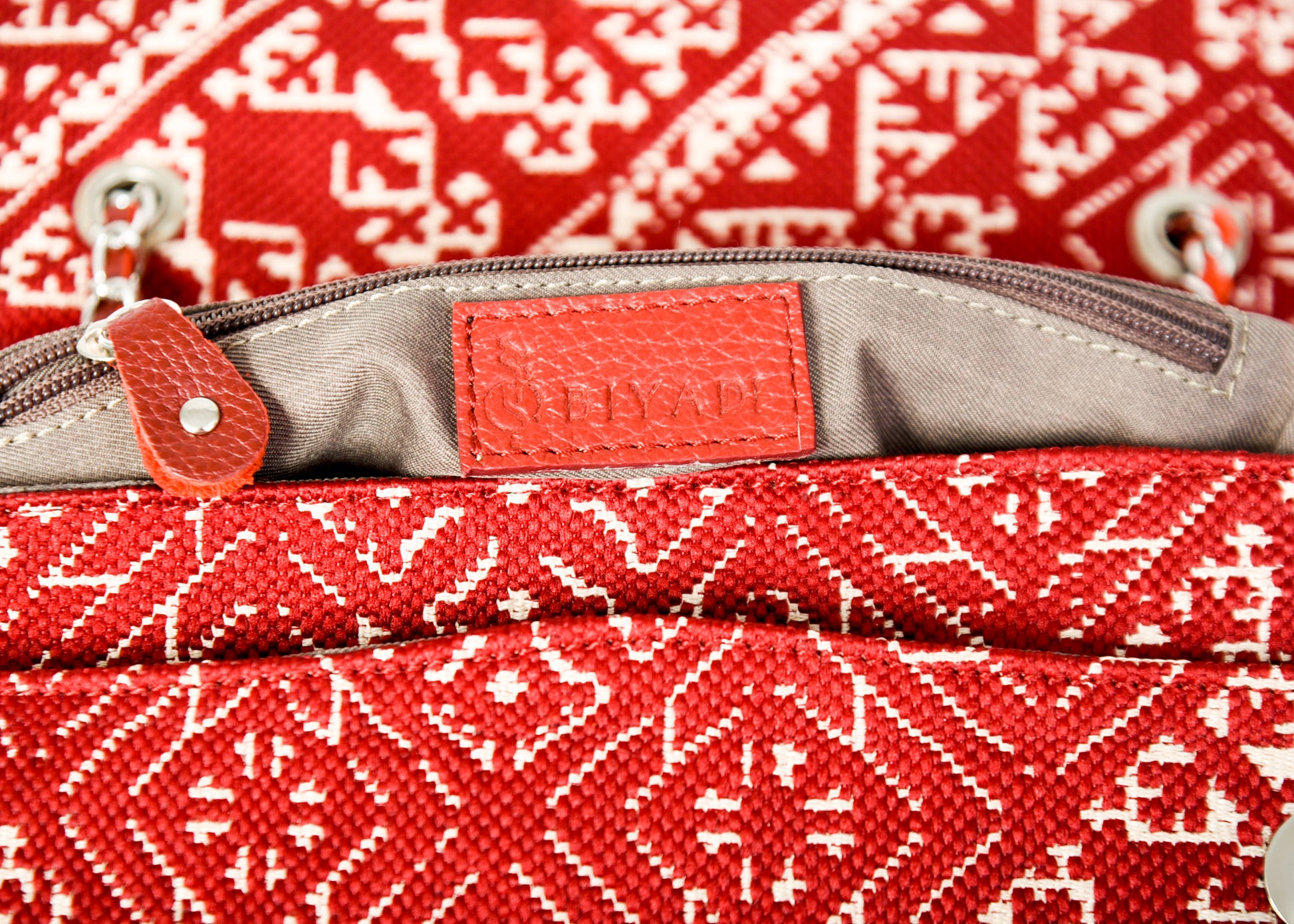Détail de l'intérieur du sac bordeaux en tissu marocain avec fermeture éclair et finitions en cuir