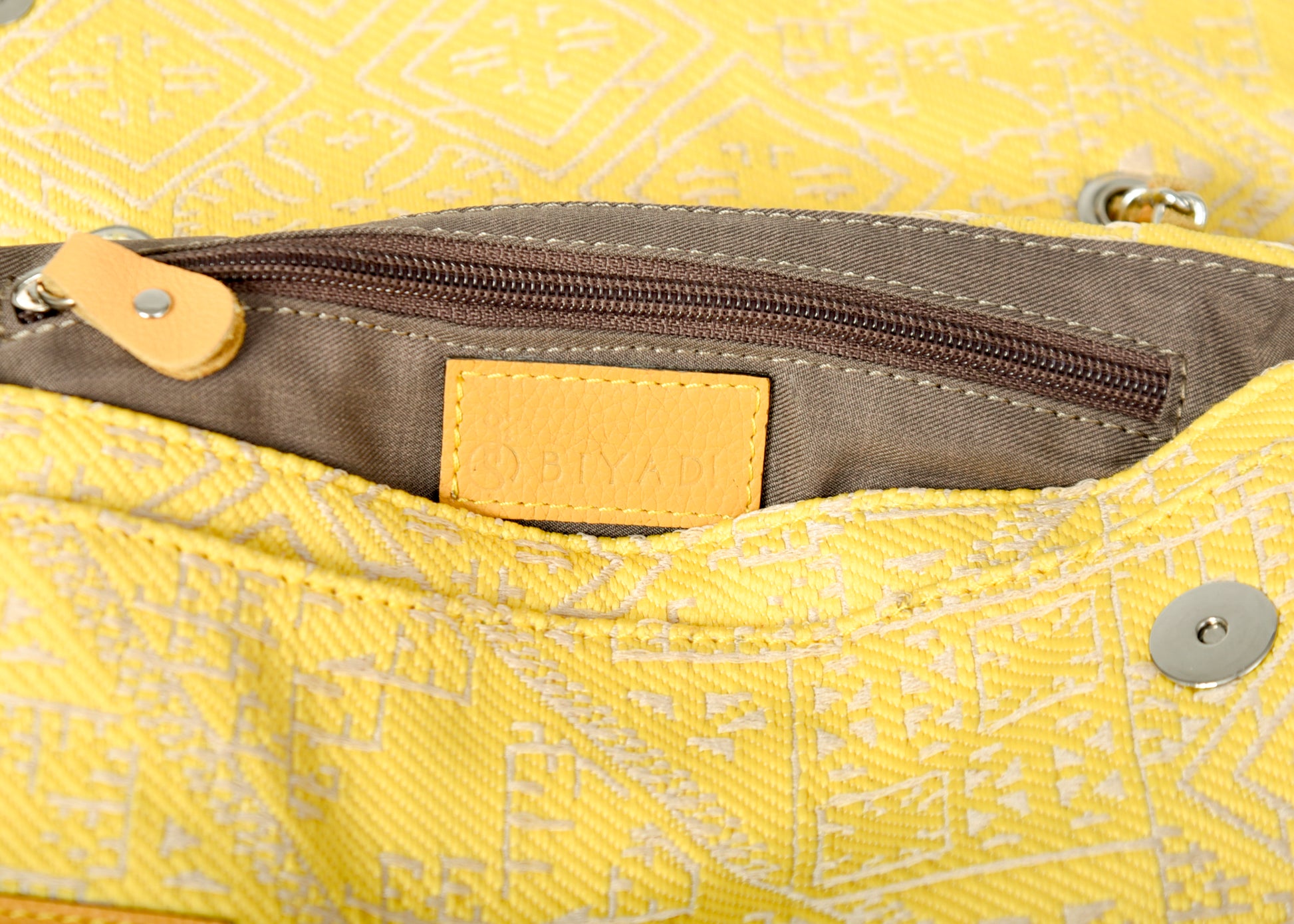 Détail de l'intérieur du sac jaune en tissu marocain avec fermeture éclair et finitions en cuir
