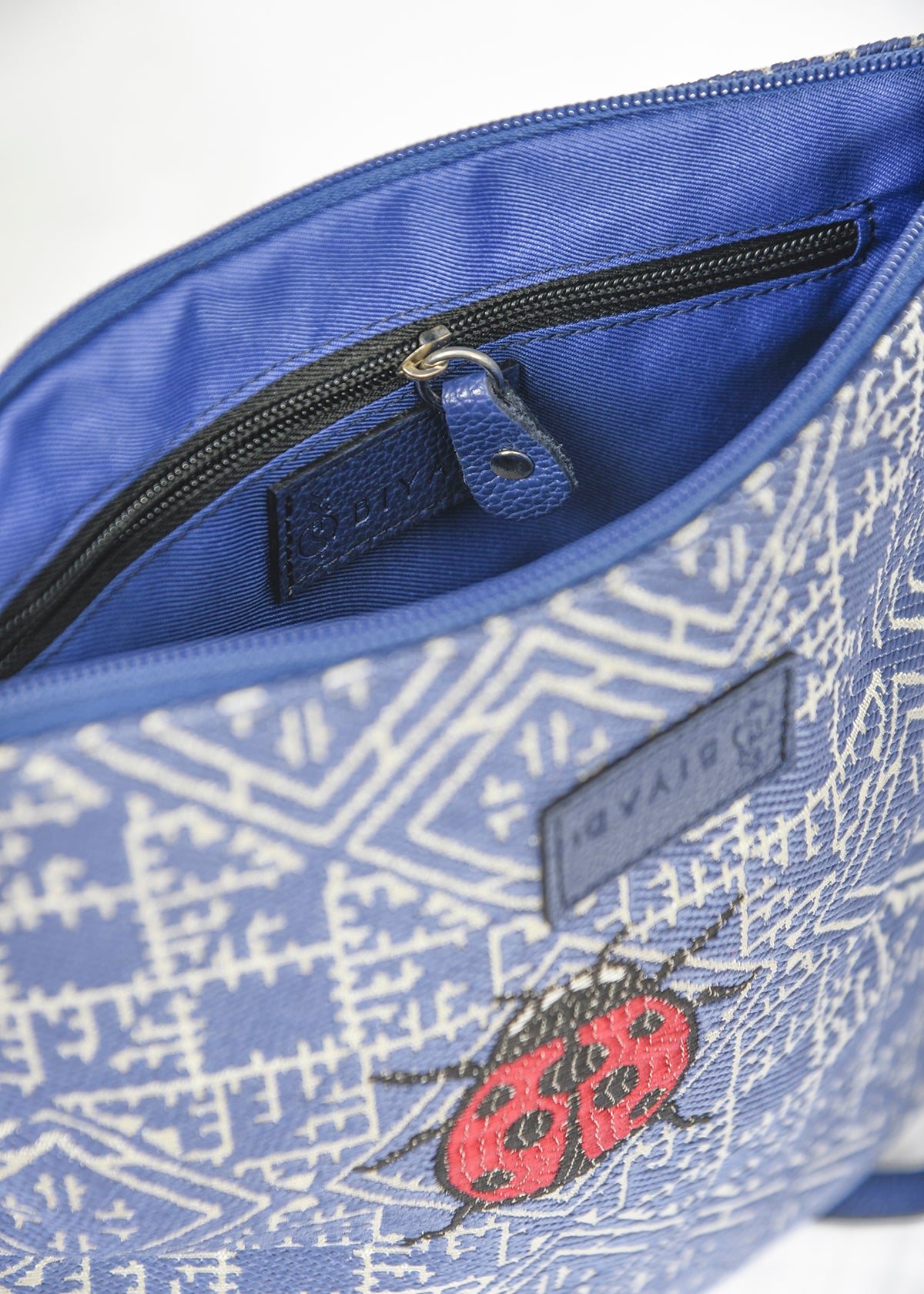 Vue intérieure du sac  bleu en tissu marocain tissé avec motif coccinelle, doublure bleue et poche intérieure zippée pour un rangement pratique.