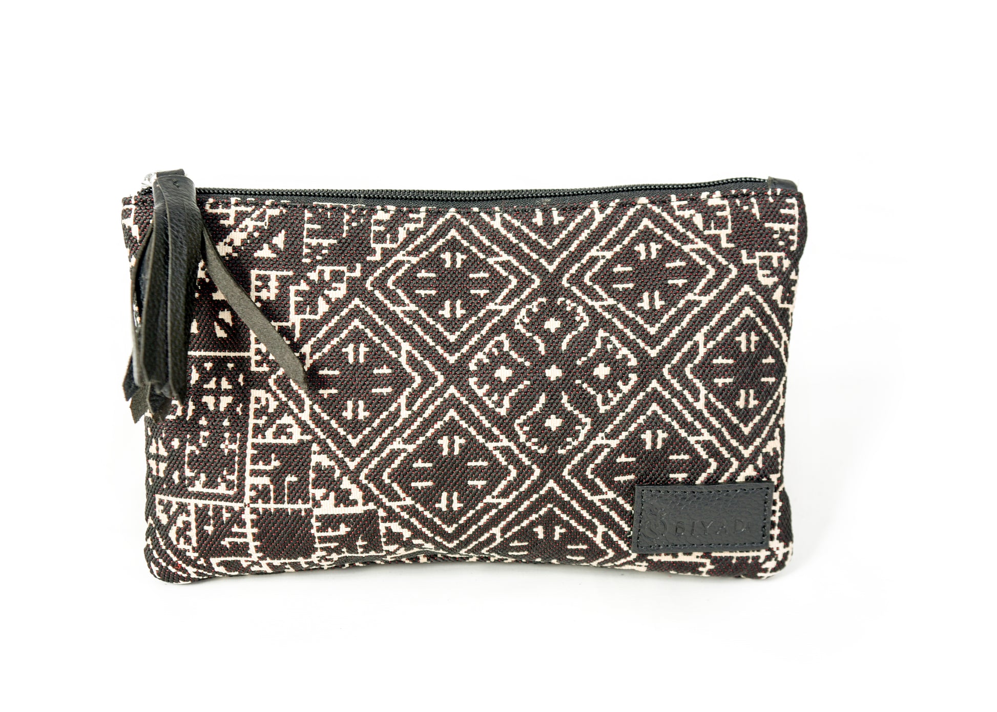 Petite pochette Tarz noir en tissu tissé marocain à motifs géométriques écrus, avec fermeture zippée et pompon en cuir noir décoratif.