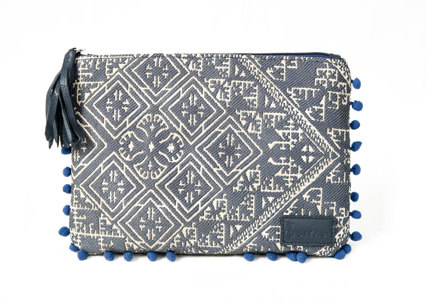 Pochette bleue marine à motif marocain tissé avec pompons décoratifs et fermeture zippée, idéale pour ranger maquillage, accessoires ou essentiels du quotidien, création Biyadi Collection.