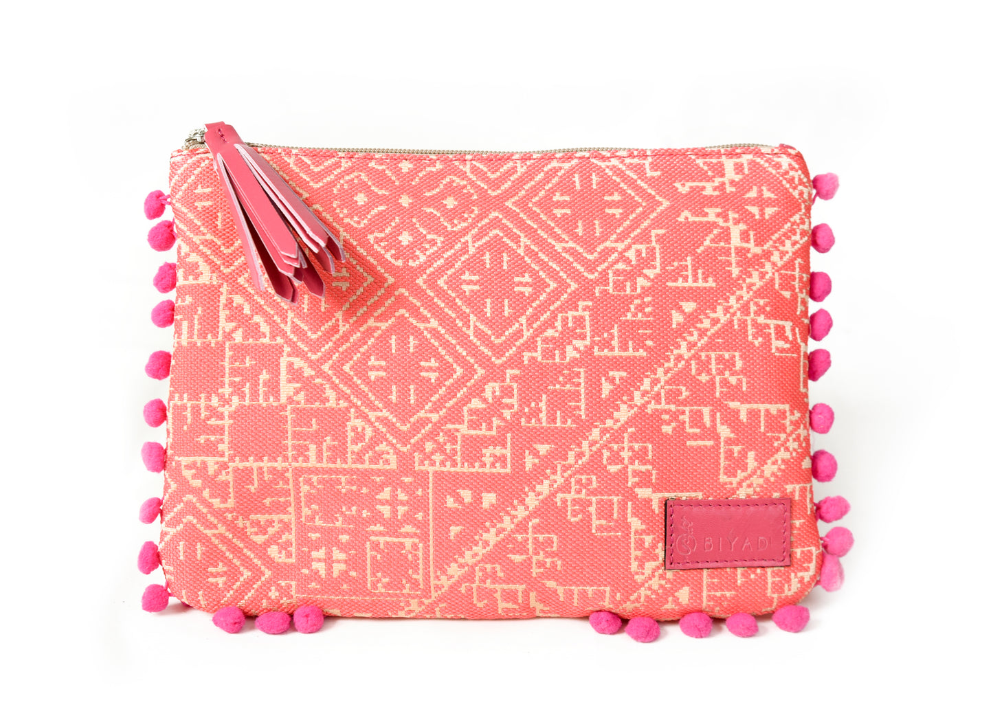 Pochette coraille à motif marocain tissé avec pompons décoratifs et fermeture zippée, idéale pour ranger maquillage, accessoires ou essentiels du quotidien, création Biyadi Collection.