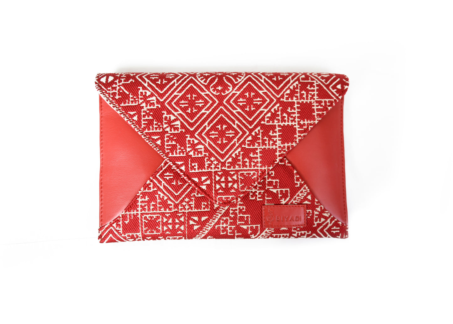 Pochette enveloppe rouge en tissu marocain tissé avec motif géométrique traditionnel et finitions en cuir, création Biyadi Collection.