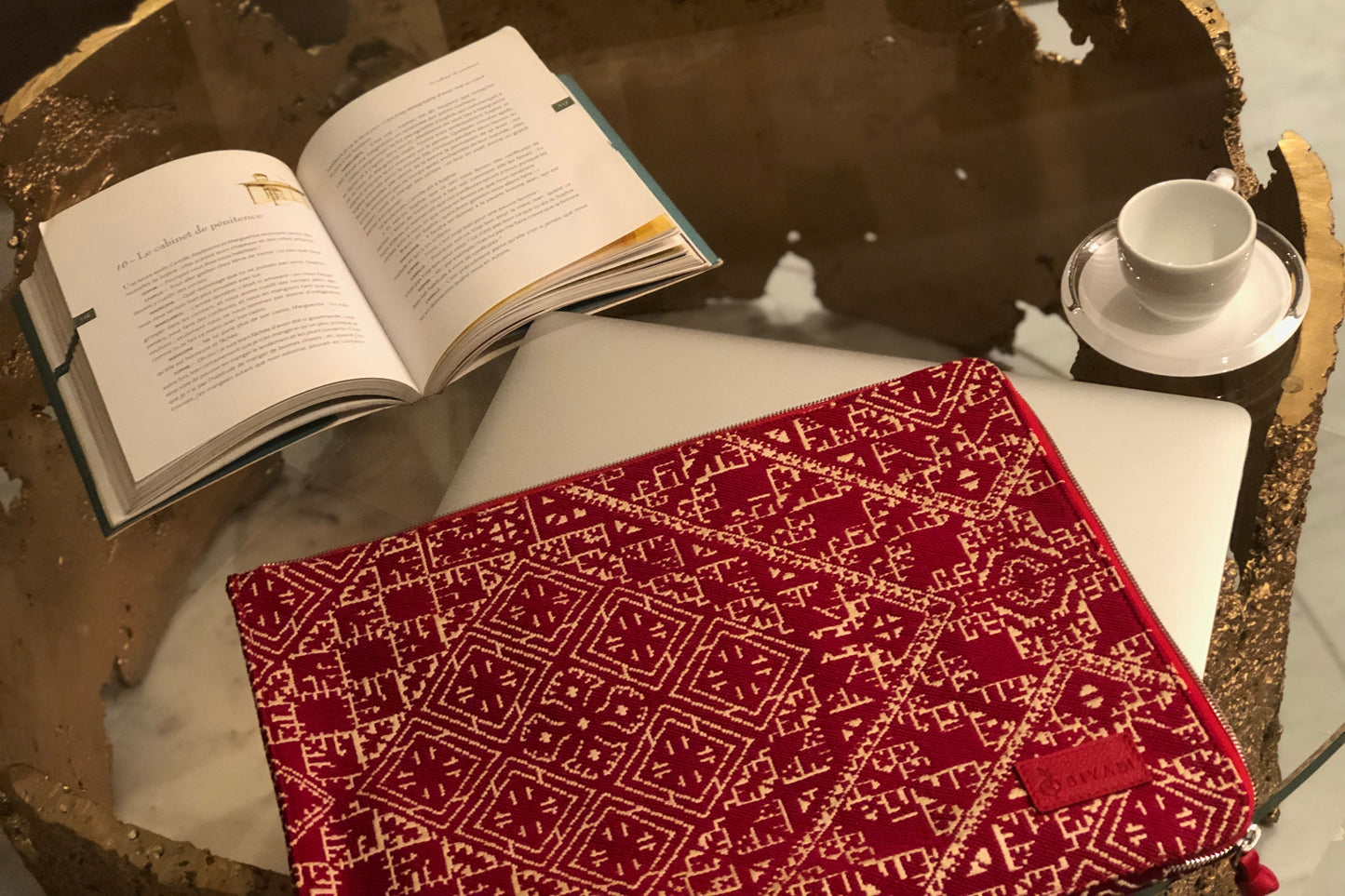 Porte-PC en tissu Tarz bordeaux et écru à motifs géométriques, posé sur un ordinateur portable.