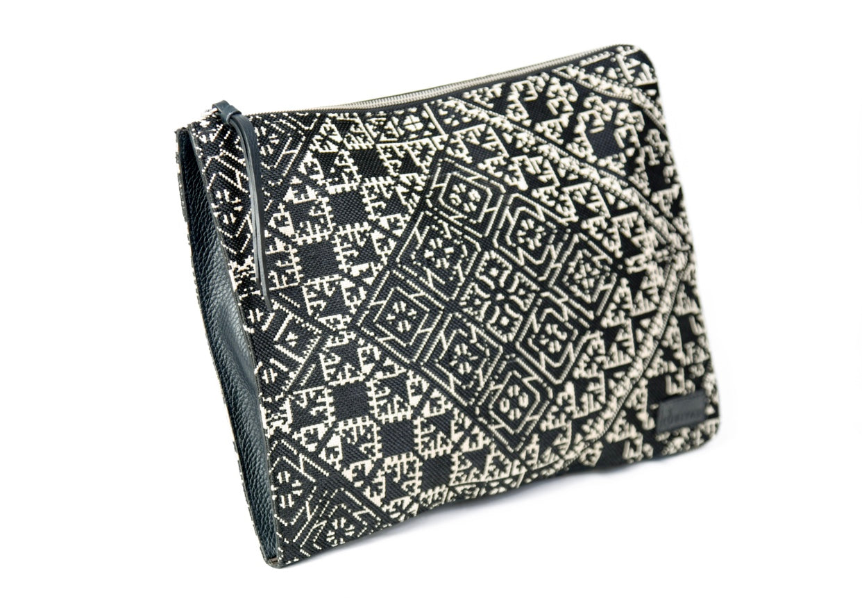 Porte pc en tissu Tarz noir et écru et cuir à motifs géométriques, avec fermeture éclair et finitions noires.
