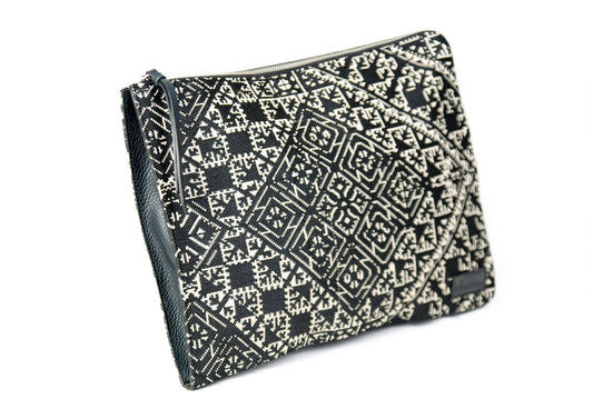Porte pc en tissu Tarz noir et écru et cuir à motifs géométriques, avec fermeture éclair et finitions noires.