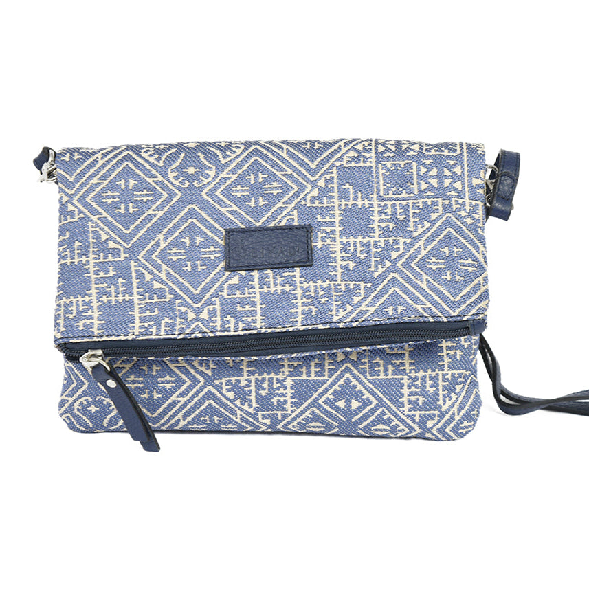 Sac bandoulière bleu en tissu marocain tissé, ornée d’un motif géométrique inspiré des broderies traditionnelles de Fès, avec fermeture zippée et finitions en cuir, création exclusive Biyadi Collection fabriquée au Maroc.