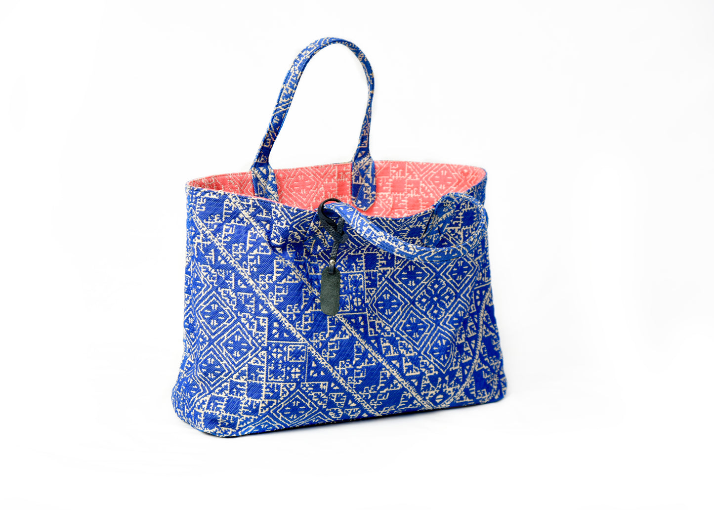 Sac cabas réversible bleucobalt et corail  en tissu marocain tissé avec anses en cuir noir et motif géométrique inspiré du patrimoine marocain.