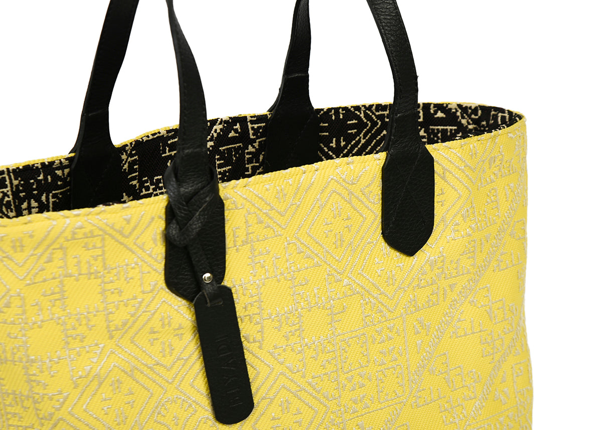 Détail du sac cabas reversible noir et jaune en tissu marocain tissé avec anse en cuir noir et étiquette en cuir Biyadi Collectio