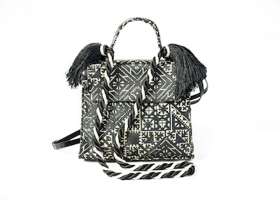 Sac à main noir et écru en tissu marocain tissé avec anses tressées, pompons en cuir et bandoulière amovible.